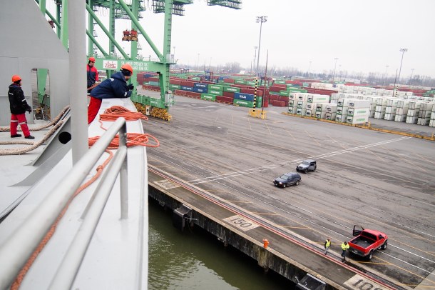 In an otherwise empty port of Tacoma, longshoremen wait at the dock to receive the mooring lines from the crew of the Ever Cthulhu.